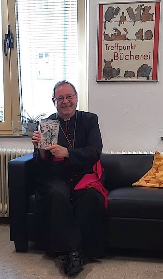 Buchempfehlung für den Bischof: "Fritz und Emma" Der Bischof zeigt das ihm empfohlene Buch "Fritz und Emma"